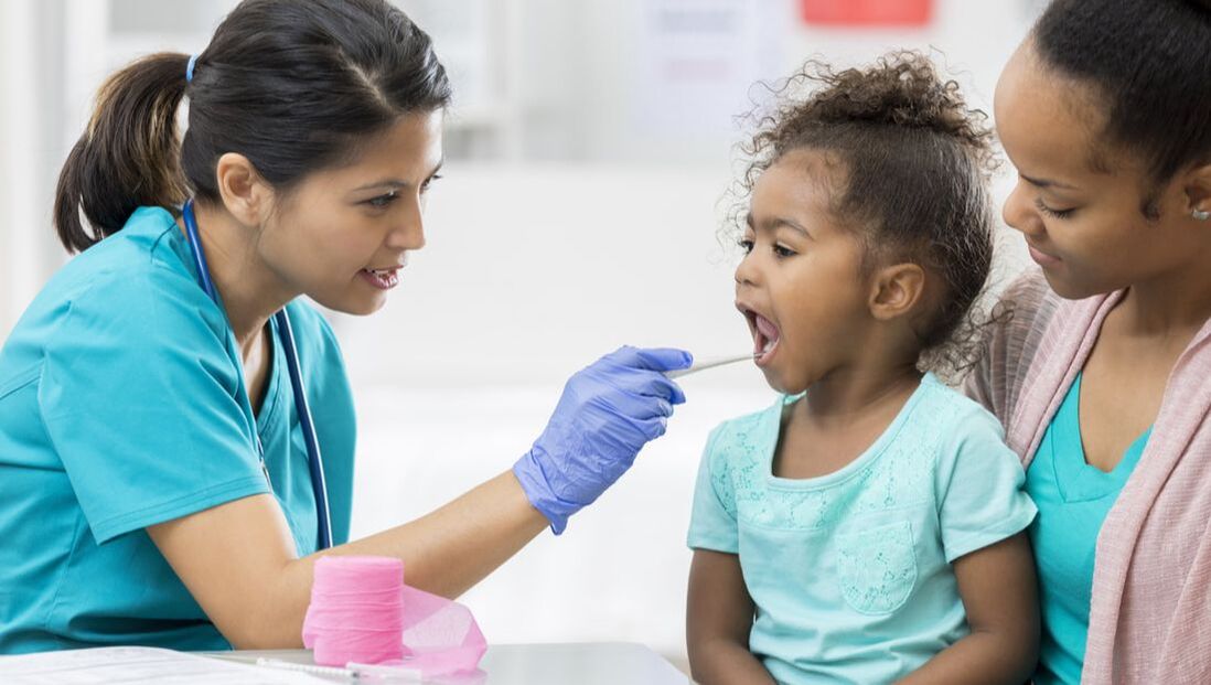 Doctor swabbing the cheek of a young patient